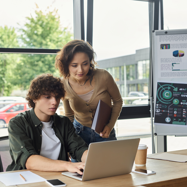 a young man and woman collaborate on projects during a productive work session in an office.